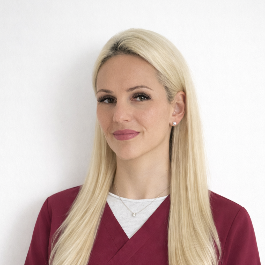 Blonde Frau mit langen Haaren und freundlichem Lächeln in roter Arbeitskleidung